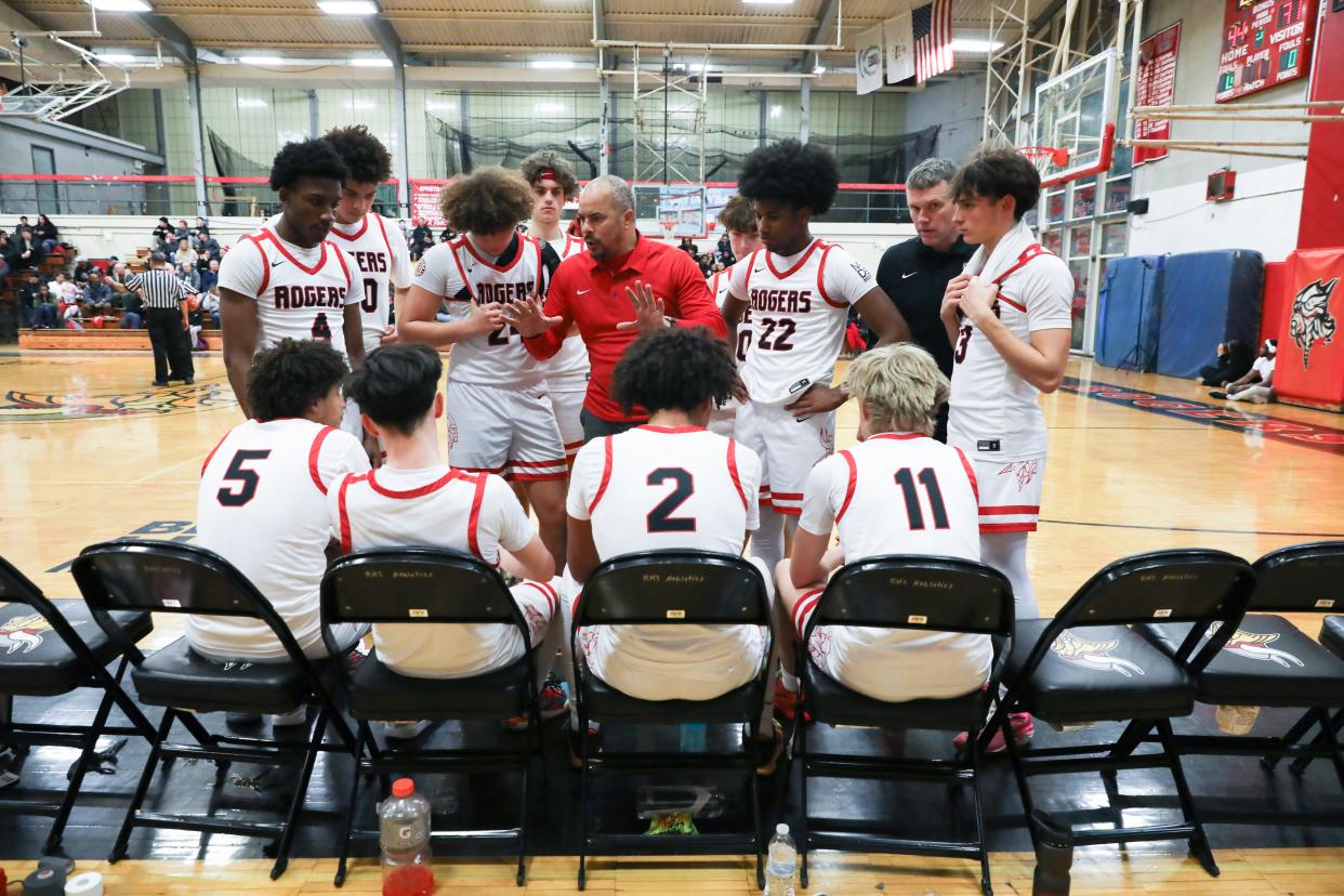 The Rogers boys basketball teams gather during Thursday night's game against Chariho.