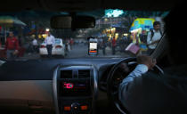 In this Wednesday, March 19, 2014 photo, an Uber taxi driver drives his car through a street in New Delhi, India. Riding on its startup success and flush with fresh capital, taxi-hailing smartphone app Uber is making a big push into Asia. The company has in the last year started operating in 18 cities in Asia and the South Pacific including Seoul, Shanghai, Bangkok, Hong Kong and five Indian cities. (AP Photo/Saurabh Das)