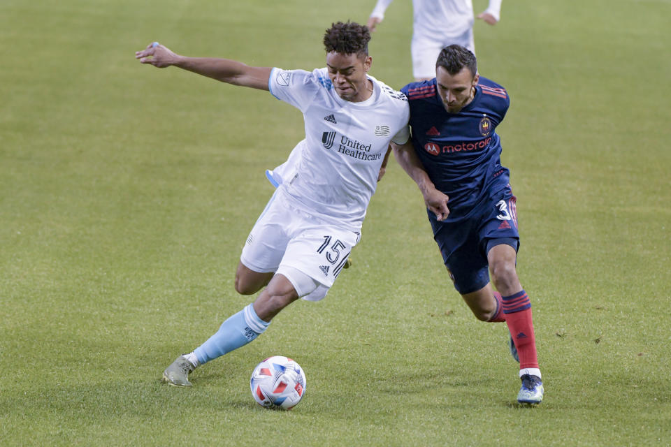 New England Revolution midfielder Brandon Bye (15) and Chicago Fire defender Jonathan Bornstein (3) work for control of the ball during the first half of an MLS soccer match in Chicago, Saturday, April 17, 2021. (AP Photo/Mark Black)