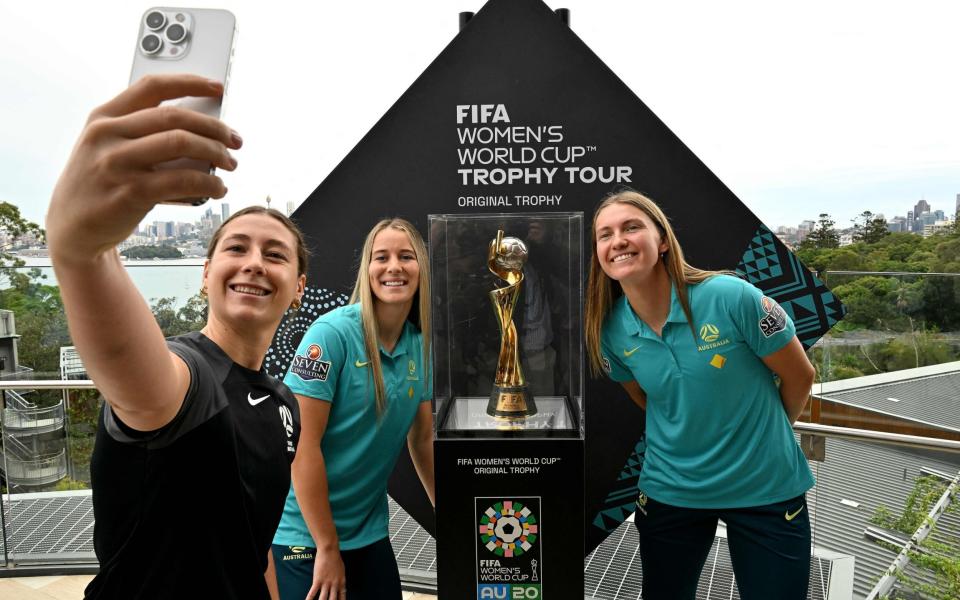 Sarah Hunter, Courtney Nevin, and Clare Hunt take selfies with the trophy during a tour at Taronga Zoo