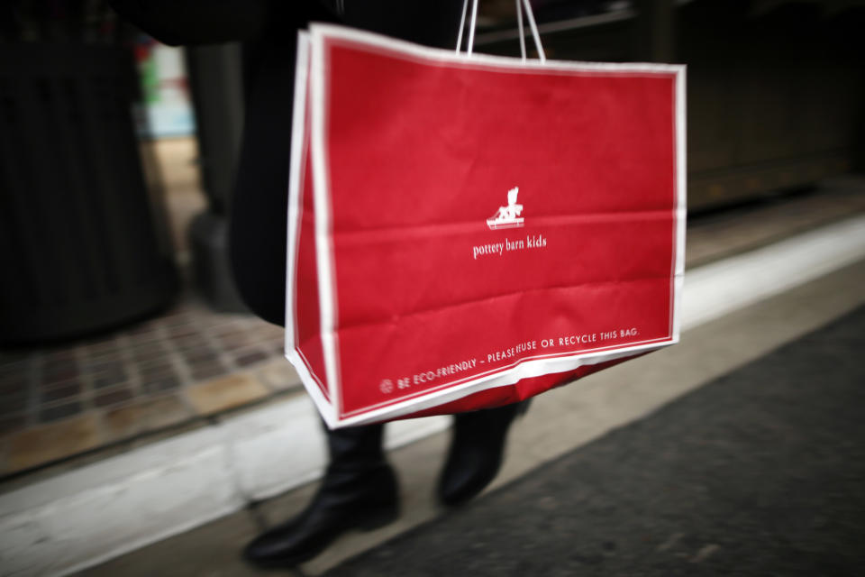 A shopper walks by with a Pottery Barn Kids bag at The Grove mall in Los Angeles November 26, 2013. This year, Black Friday starts earlier than ever, with some retailers opening early on Thanksgiving evening. About 140 million people were expected to shop over the four-day weekend, according to the National Retail Federation. REUTERS/Lucy Nicholson (UNITED STATES - Tags: BUSINESS)