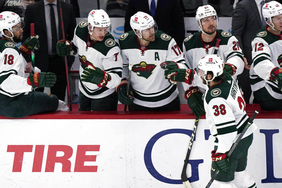 Minnesota Wild right wing Ryan Hartman (38) celebrates with teammates after scoring a goal against the Chicago Blackhawks during the first period of an NHL hockey game in Chicago, Friday, Jan. 21, 2022. (AP Photo/Nam Y. Huh)