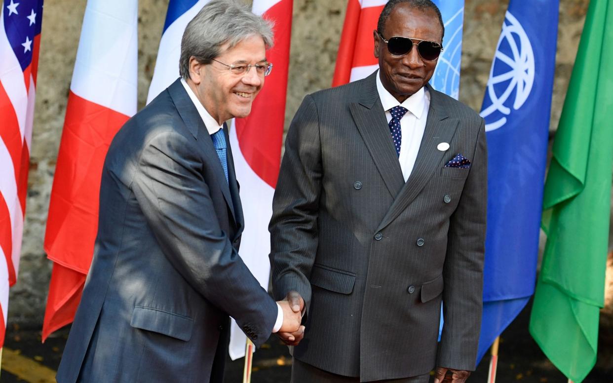 Italian Prime Minister Paolo Gentiloni welcomes Guinean President and Chairman of the African Union Alpha Conde as he arrives at the Hotel San Domenico on the second day of the G7 summit of Heads of State and of Government, on May 27, 2017 in Taormina, Sicily. - AFP