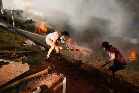 Residents work to prevent a wildfire from spreading to their homes in Vina del Mar. REUTERS/Rodrigo Garrido