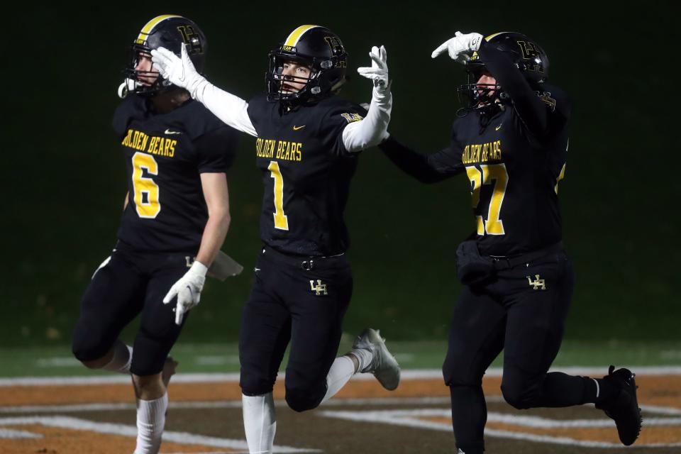 Upper Arlington's Sam Cannon (1), Luke Frederick (6) and Dino Gesouras (27) celebrate Cannon's 94-yard kickoff return for a touchdown during a Division I OHSAA State Semifinal game against Lakewood St. Edward on Nov. 26, 2021, at Mansfield Senior High School's Arlin Field in Mansfield, Ohio.