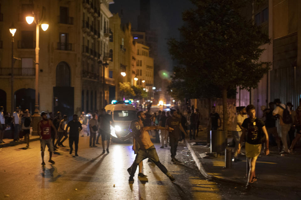 Anti-government protesters throw stones and clash with the riot police, during a protest against the political elites who have ruled the country for decades, in Beirut, Lebanon, Thursday, Aug. 6, 2020. (AP Photo/Hassan Ammar)