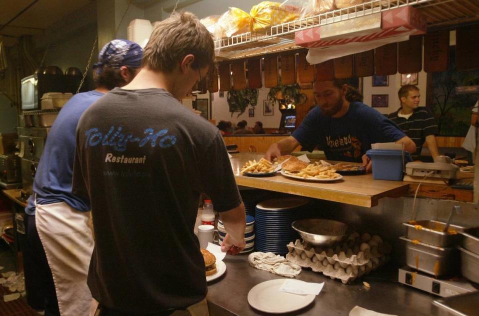 Photo taken Saturday 07/31/04 by Jim Winn. Aaron Milling (Tolly Ho shirt) and Reat Haynes (Bandana) work the kitchen at Tolly Ho in Lexington while Andrew Cook picks up an order early Saturday morning at 2:20 a.m. 7/31/04.