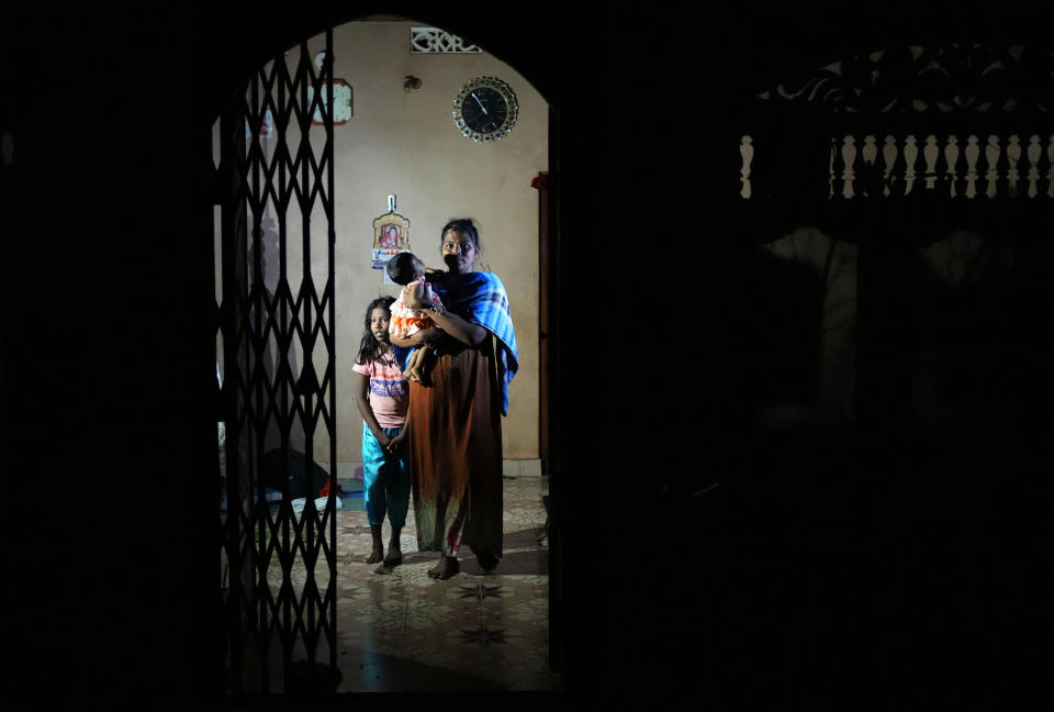 Rasarathnam Anushiya and her children wait at their rented house in Vavuniya, about 250 kilometres north east of Colombo, Sri Lanka, Tuesday, Dec. 13, 2022. Due to Sri Lanka's current economic crisis families across the nation have been forced to cut back on food and other vital items because of shortages of money and high inflation. Many families say that they can barely manage one or two meals a day. (AP Photo/Eranga Jayawardena)