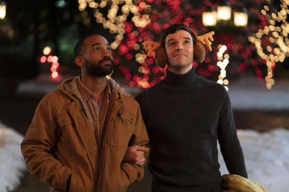 Peter, who's wearing reindeer earmuffs, stands arm-in-arm with James outside