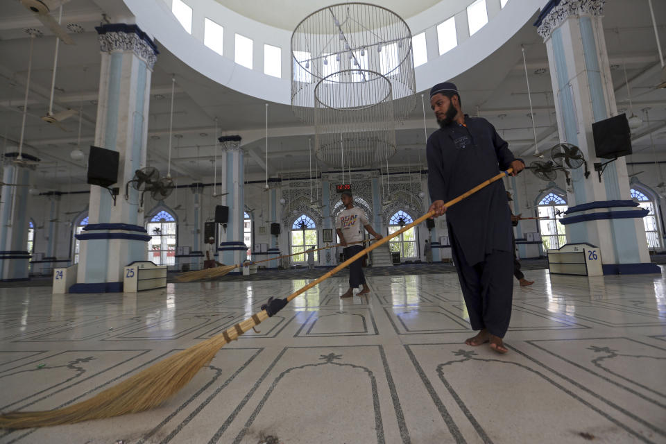 Volunteers clean the main hall at a mosque ahead of the upcoming Muslim fasting month of Ramadan, in Karachi, Pakistan, Saturday, April 2, 2022. The Muslim holy month of Ramadan — when the faithful fast from dawn to dusk — began at sunrise Saturday in much of the Middle East, where Russia's invasion of Ukraine has sent energy and food prices soaring. (AP Photo/Fareed Khan)