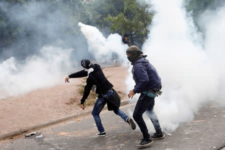 A supporter of Salvador Nasralla, presidential candidate for the Opposition Alliance Against the Dictatorship, throws a tear gas canister during a clash with riot police as they wait for official presidential election results in Tegucigalpa, Honduras, November 30, 2017. REUTERS/Edgard Garrido