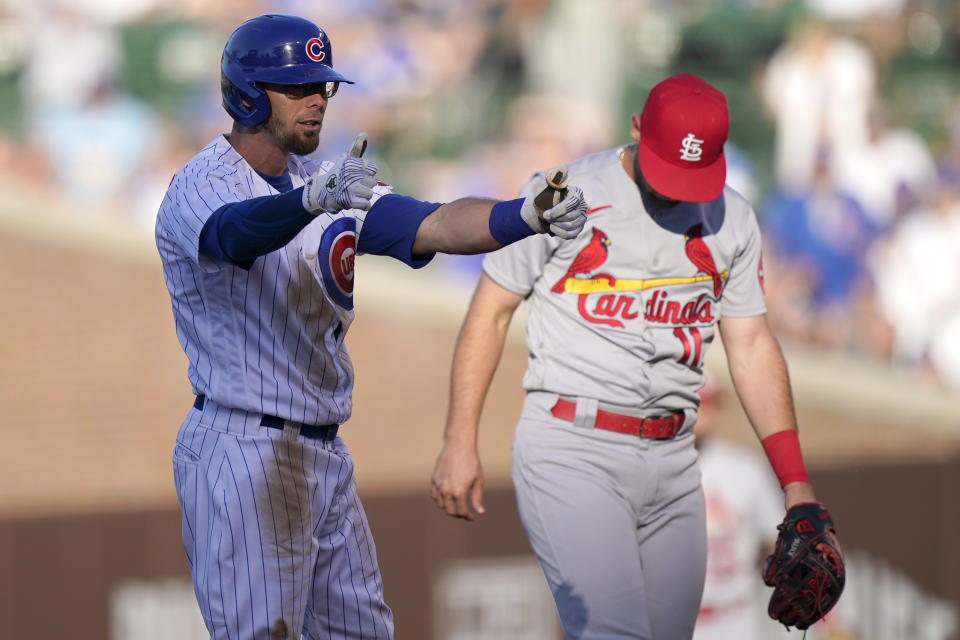 Chicago Cubs' Eric Sogard, left, celebrates after hitting a double as St. Louis Cardinals shortstop Paul DeJong looks down during the third inning of a baseball game in Chicago, Sunday, June 13, 2021. (AP Photo/Nam Y. Huh)