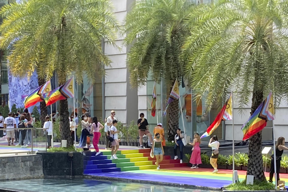 People walk along a rainbow-colored walkway outside a Bangkok mall during Pride celebrations on Sunday, June 4, 2023. LGBTQ+ people from China who are frequently scorned and ostracized at home are coming to Thailand in droves. They're drawn by the freedom to be themselves. Bangkok is only a 5-hour flight from Beijing, and Thailand's tourism authorities actively promote its status as among the most open to LGBTQ+ people in the region.(AP Photo/Donna Edwards)
