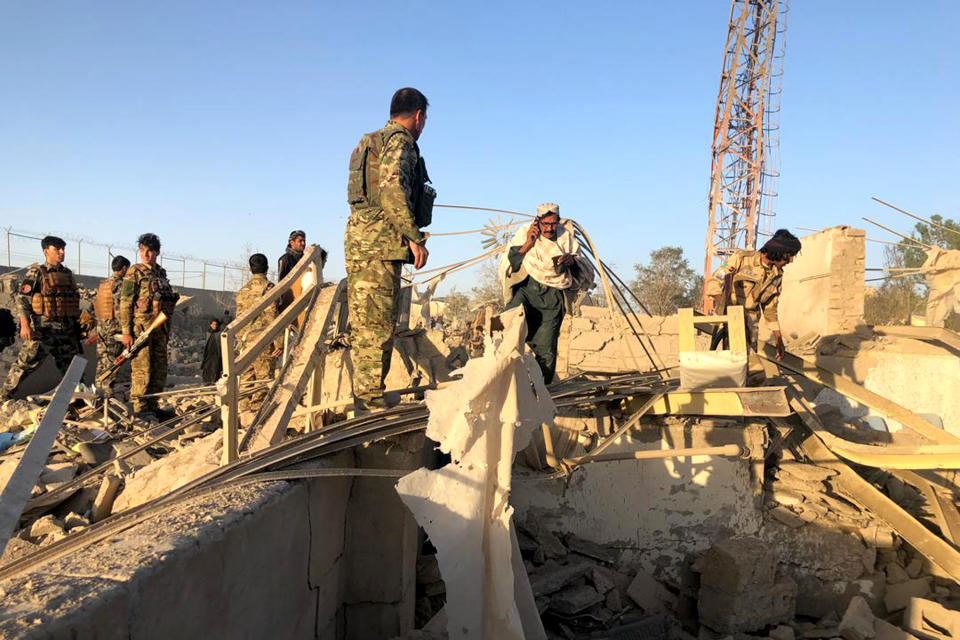 Afghan security members and people work at the site of a suicide attack in Zabul, Afghanistan, Thursday, Sept. 19, 2019. A powerful early morning suicide truck bomb devastated a hospital in southern Afghanistan on Thursday. (AP Photo/Ahmad Wali Sarhadi)