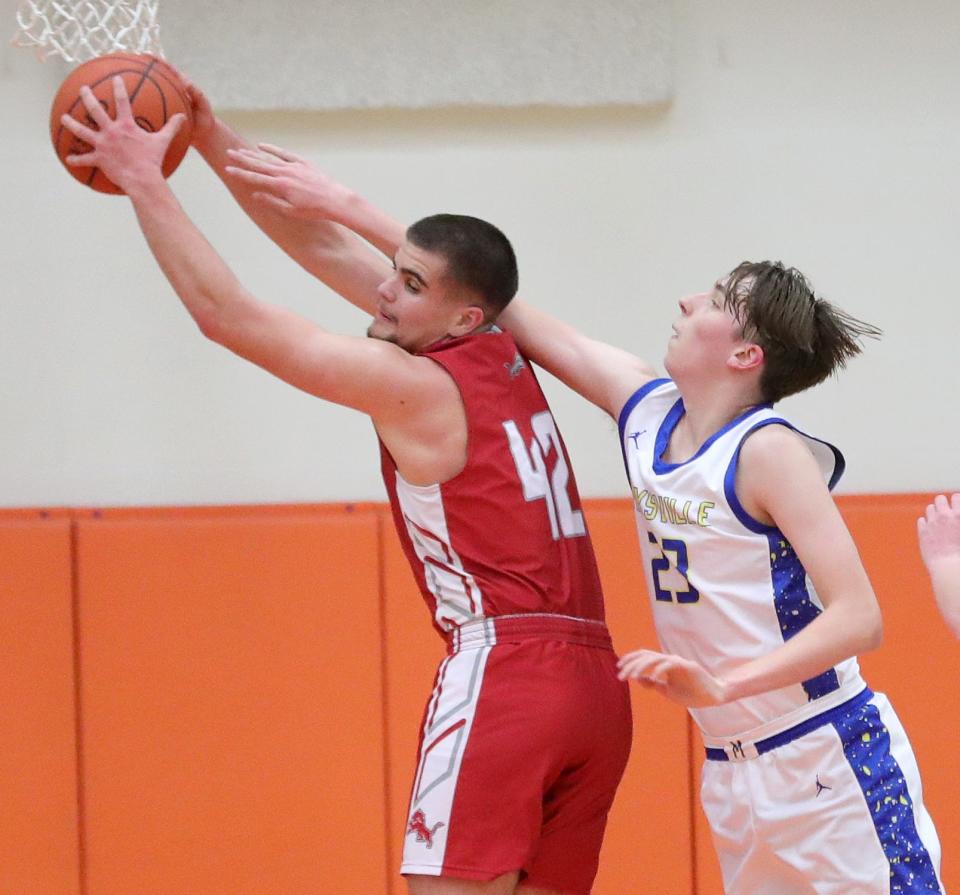 Minerva's Miles Miller, left, pulls down a rebound defended by Maysville's Kane Roehrig during a district semifinal, Wednesday, March 6, 2024, at Claymont High School.