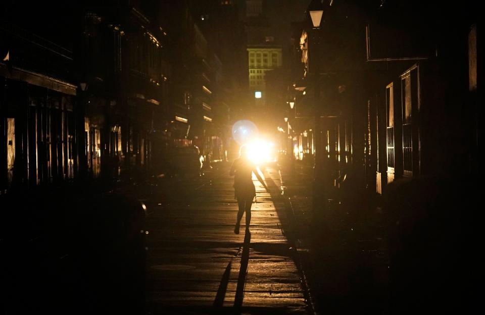 A police officer patrols past woman walking along Bourbon Street (AP Photo/Eric Gay)