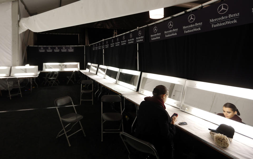 A model sits alone backstage before the Monique Lhuillier Fall 2013 collection is modeled during Fashion Week, Saturday, Feb. 9, 2013 in New York. (AP Photo/Jason DeCrow)