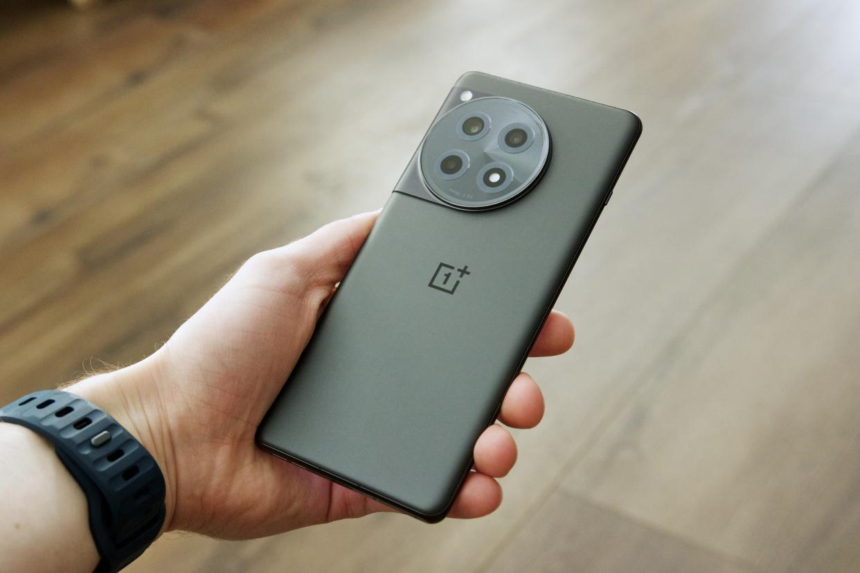 Someone holding the OnePlus 12R, showing the back of the phone.