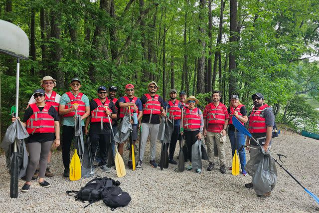 <p>Hewlett Packard</p> Hewlett Packard team members in Durham, N.C., work to clear trash from a lake on canoes at William B. Umstead State Park on May 9.