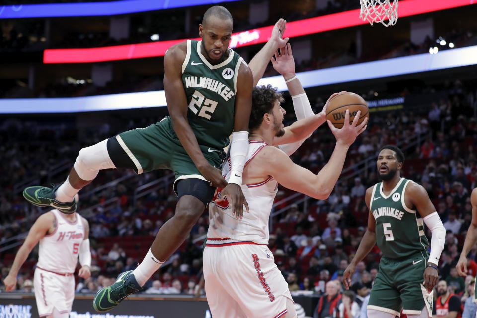 Milwaukee Bucks forward Khris Middleton (22) fouls Houston Rockets center Alperen Sengun, front right, who shoots during the first half of an NBA basketball game Saturday, Jan. 6, 2024, in Houston. (AP Photo/Michael Wyke)