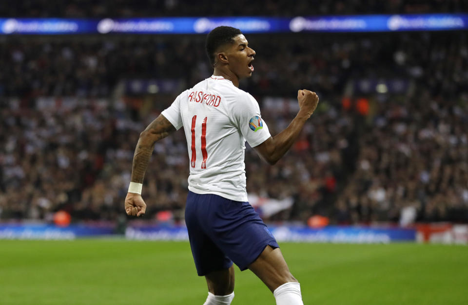 FILE - In this Thursday, Nov. 14, 2019 file photo England's Marcus Rashford celebrates scoring his side's fourth goal during the Euro 2020 group A qualifying soccer match between England and Montenegro at Wembley stadium in London. British Prime Minister Boris Johnson made an abrupt about-face Tuesday June 16, 2020 and agreed to keep funding meals for needy pupils over the summer holidays, after a campaign headed by young soccer star Marcus Rashford. The Manchester United and England player has been pressing the government not to stop a meal voucher program at the end of the school term in July. (AP Photo/Kirsty Wigglesworth, File)