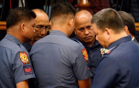 Philippine National Police chief Director-General Ronald dela Rosa (2nd-R) talks to fellow police officers during a Senate hearing regarding people killed during a crackdown on illegal drugs in Pasay, Metro Manila, Philippines August 23, 2016. REUTERS/Erik De Castro