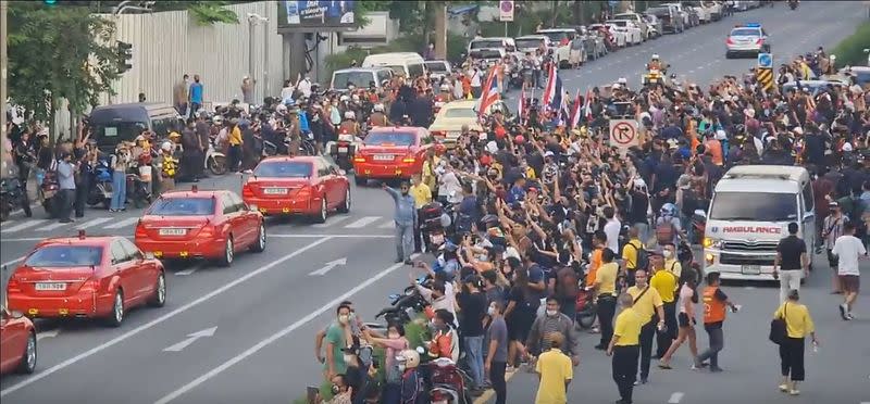 Social media video still of the royal motorcade carrying Thailand's Queen Suthida and Prince Dipangkorn driving past a group of anti-government demonstrators in Bangkok