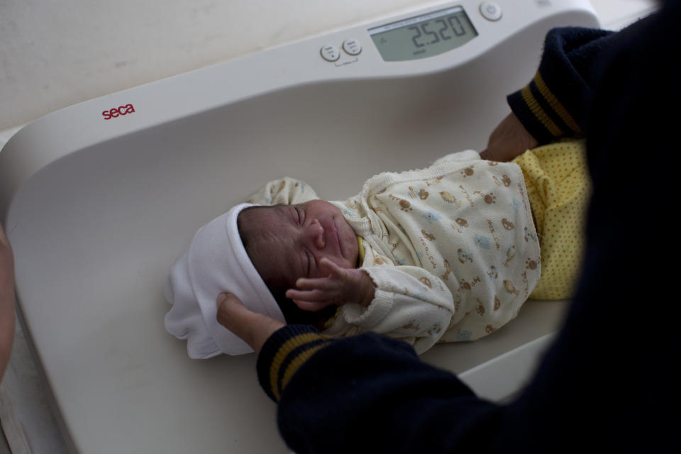 In this Tuesday, Feb. 11, 2014 photo, a Mixteco indigenous baby is weighed at a health clinic in Cochoapa El Grande, Mexico. The head of Mexico’s anti-poverty program drew criticism Monday, Ma5 5, 2014, after she warned Indian mothers that government aid programs would only help support their first three children. (AP Photo/Dario Lopez-Mills)