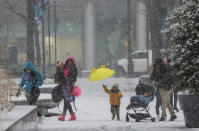 A family makes their way across Dilworth Plaza on west side of City Hall on a cold, wet, snowy morning in Philadelphia Tuesday morning, Feb. 13, 2024. (Alejandro A. Alvarez/The Philadelphia Inquirer via AP)