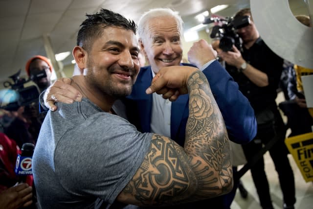 Democratic presidential candidate Joe Biden flexes his arm along with Jaime Karnilaw of Concord, New Hampshire