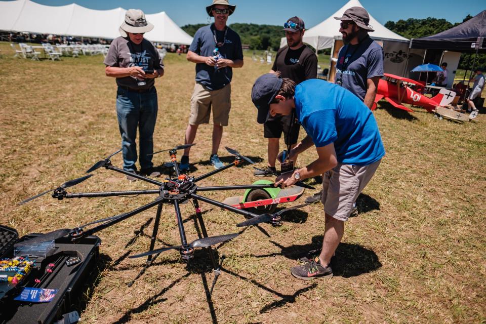 Ethan Hedrick, a producer for Pilot Institute in Prescott, AZ, prepares 'Octazilla', an Octocopter made entirely of carbon fibre, during ‘Flite Fest’ in Malvern, Friday, June 24. The copter was manufactured and assembled entirely by hand by Don Heon, pictured top right, speaking to enthusiasts.