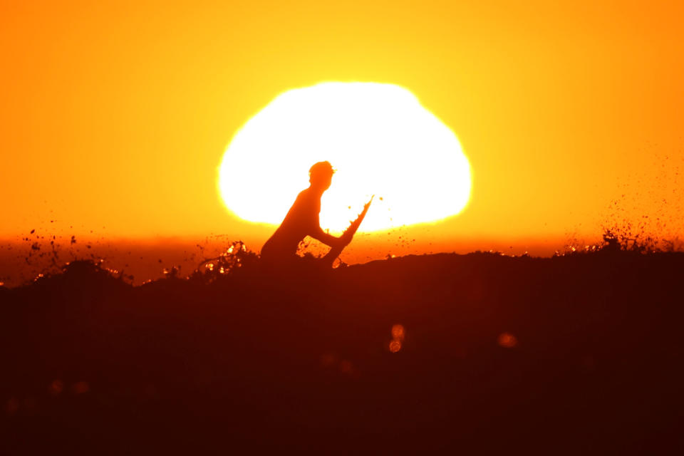 A surfer pulls off a wave as the sun sets in Cardiff during what local media reported to be a record breaking heat wave in Southern California, U.S., October 24, 2017. REUTERS/Mike Blake