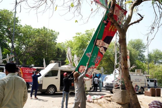 Municipal workers remove Imran Khan posters in Lahore, Pakistan, May 20, 2023.<span class="copyright">K.M. Chaudary/AP</span>