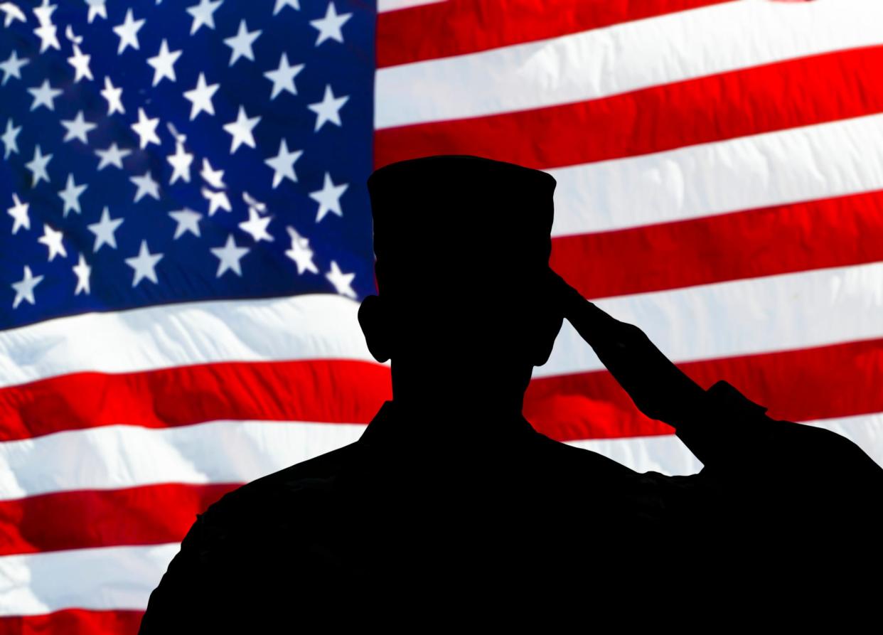 Proud saluting male army soldier on american flag background