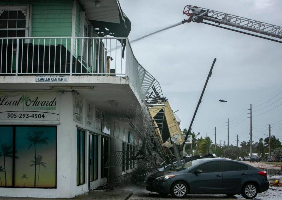 A door can be seen falling as part of the structure collapsed after a fire that broke out in a building on Flagler Avenue in Key West, Florida, early Wednesday morning, Sept. 28, 2022.