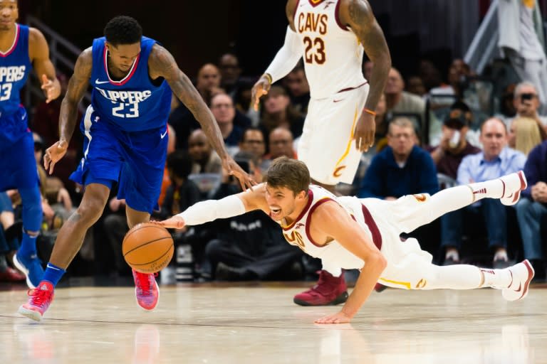 Lou Williams (L) of the LA Clippers and Kyle Korver of the Cleveland Cavaliers dive for a loose ball at Quicken Loans Arena