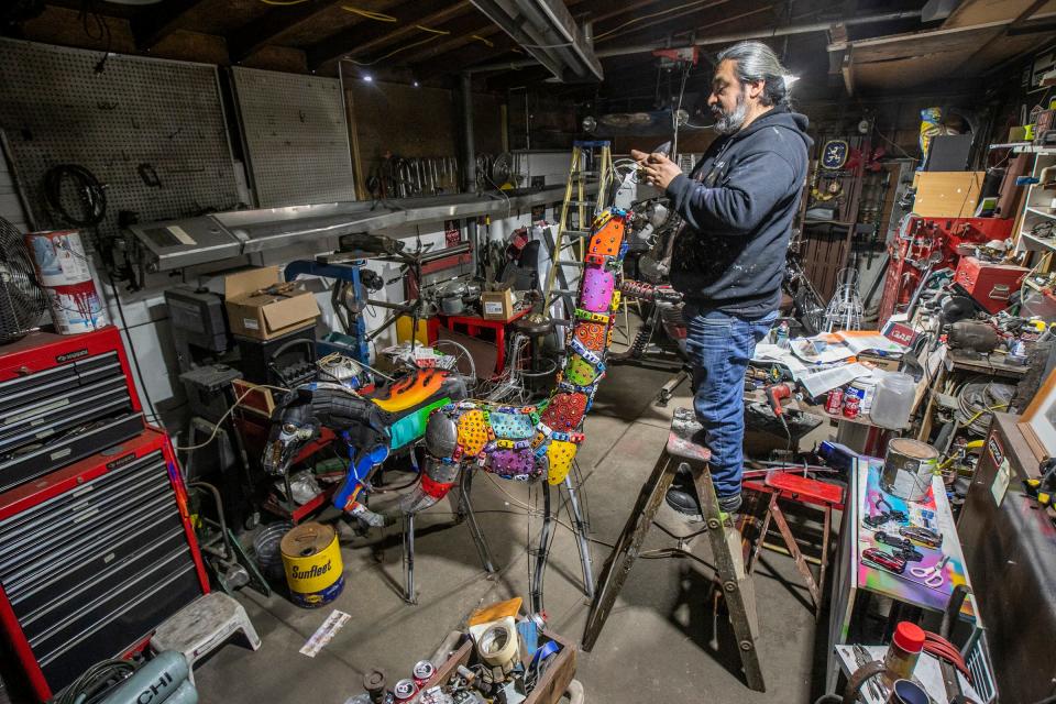 Elton Monroy Duran, 45, of Detroit, works on a giraffe Alebrijes he is making out of automobile parts in his garage studio in Detroit on Feb. 8, 2024. Duran repaired cars with his father in the family business growing up in Tula, Hidalgo, Mexico and uses his knowledge of vehicles to sculpt the Alebrijes, mystical, vibrant Mexican creatures of the spirit world.