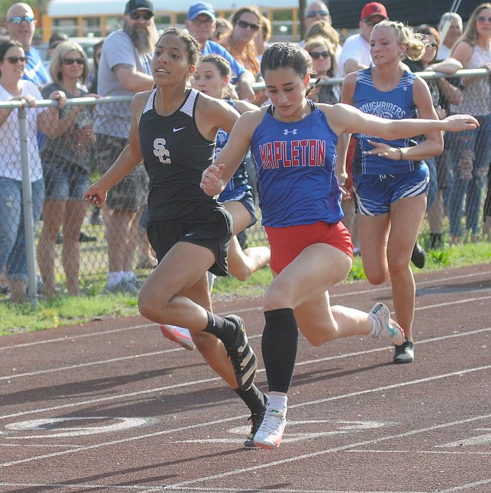 Jillian Carrick races Angela Williams in the 100 meters during the Firelands Conference Championships at New London Friday, May 13, 2022.