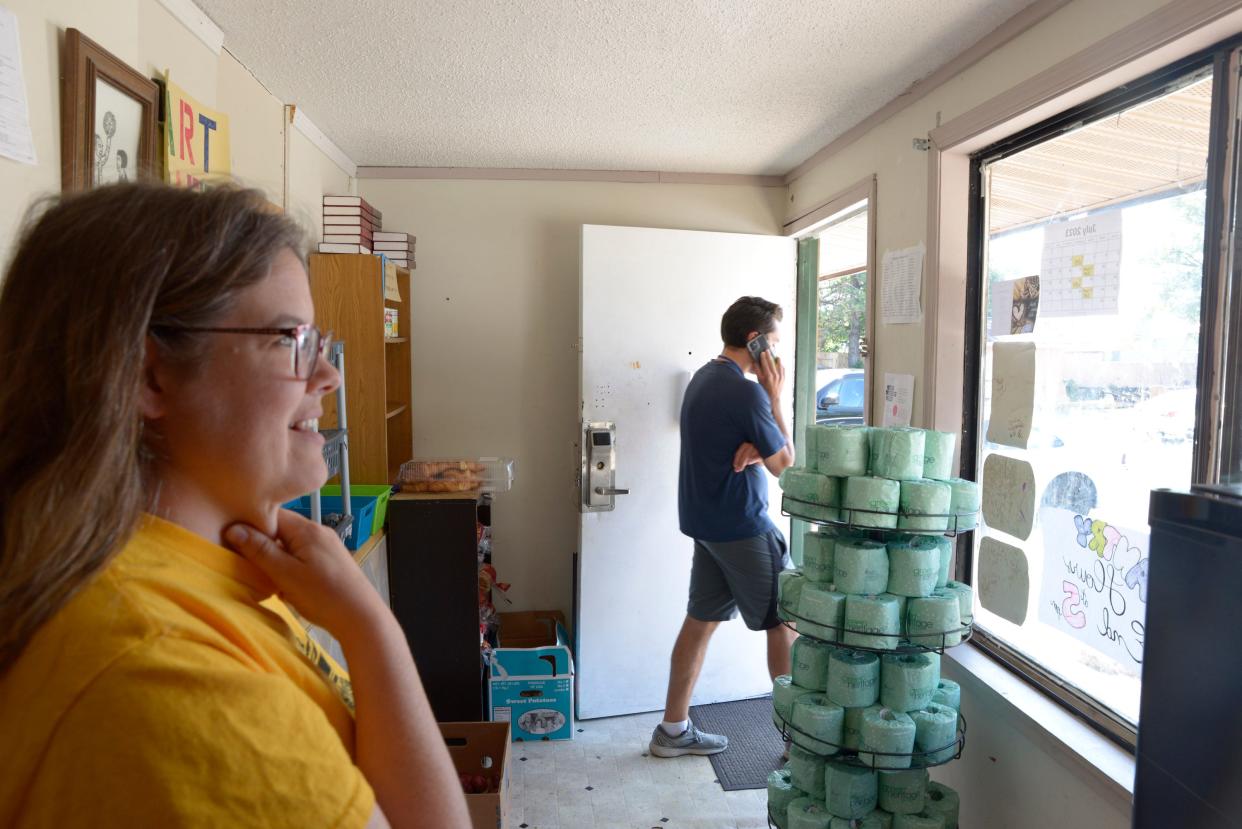 Sheila McCarthy, director of Motels4Now, speaks to a resident outside of the window to her office on Friday, July 14, 2023.