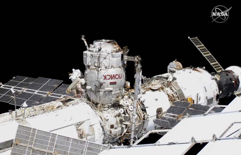 This photo provided by NASA shows Russian astronauts Commander Sergey Ryzhikov, left in red stripes, and Sergey Kud-Sverchkov, back left, on a spacewalk outside of the International Space Station on Wednesday, Nov. 18, 2020, as they prepare for next year's arrival of a long-delayed lab. (NASA via AP)