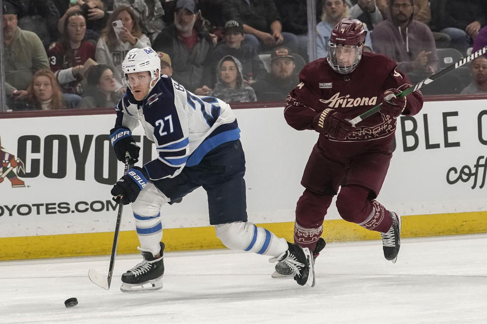 Winnipeg Jets' Nikolaj Ehlers (27) chases the puck in front Arizona Coyotes' Juuso Valimaki (4) during the second period of an NHL hockey game Sunday, Jan. 7, 2024, in Tempe, Ariz. (AP Photo/Darryl Webb)