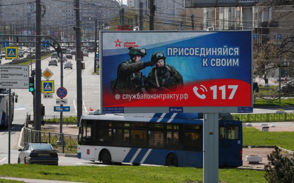A digital billboard shows Russian soldiers with a slogan reading 'Join your comrades. Contract service' in St. Petersburg, Russia - ANATOLY MALTSEV/EPA-EFE/Shutterstock/Shutterstock