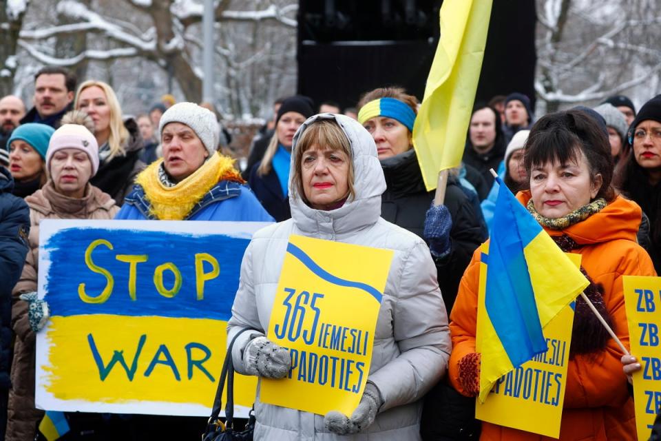 People hold a rally to mark the first anniversary of the Russian invasion of Ukraine at the Freedom Monument in Riga, Latvia (EPA)