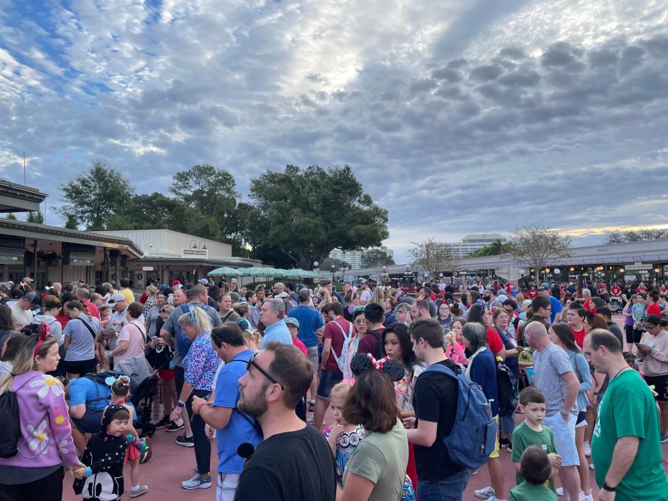 crowds of people outside of magic kingdom buying tickets and waiting to enter the park