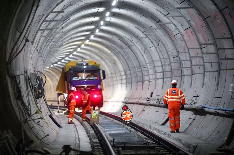 Employees stand in a tunnel at the Stepney Green interchange, developed by Crossrail, as it runs beneath London