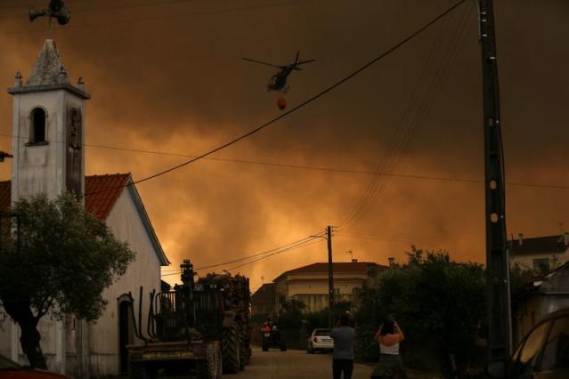 People evacuate after a wild fire, in Leiria