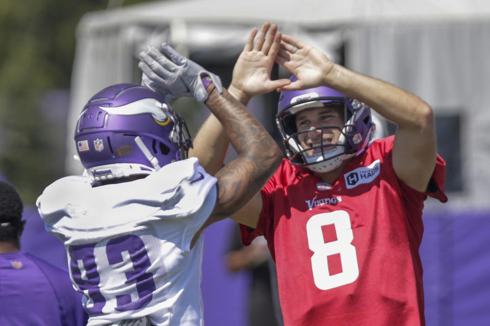 Minnesota Vikings' Kirk Cousins (8) celebrates with Vikings receiver Jalen Nailor (83) at the NFL football team's practice facility in Eagan, Minn., Monday, Aug. 1, 2022. (AP Photo/Andy Clayton-King)