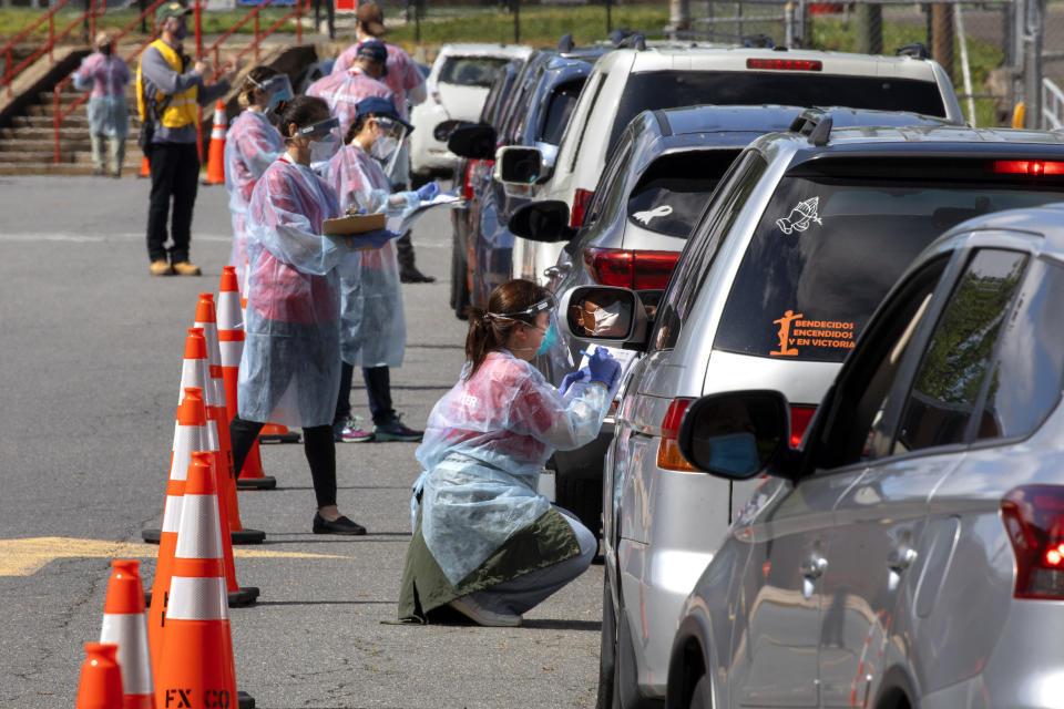 A man wearing a facemask waits inside his car to be tested for COVID-19 as volunteers take registration information in Annandale, Va., Saturday, May 23, 2020. COVID-19 testing was available from Fairfax County at no cost and without a doctor's order. Hundreds of people had lined up in cars and on foot by 10am. Officials planned on testing about 1000 people from 10 a.m. to 6 p.m. Testing will be available at Bailey's Elementary on Sunday. (AP Photo/Jacquelyn Martin)