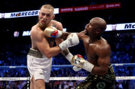 <p>(L-R) Floyd Mayweather Jr. throws a punch at Conor McGregor during their super welterweight boxing match on August 26, 2017 at T-Mobile Arena in Las Vegas, Nevada. </p>