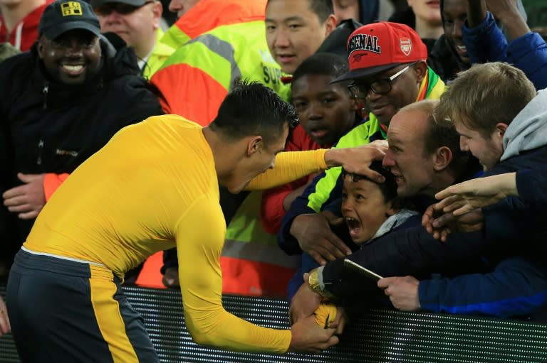 Arsenal's striker Alexis Sanchez gives his match shirt to a young fan following a win over Middlesbrough on April 17, 2017